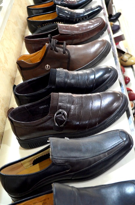 The picture portrays a row of men's shoes in a shoe store. 
